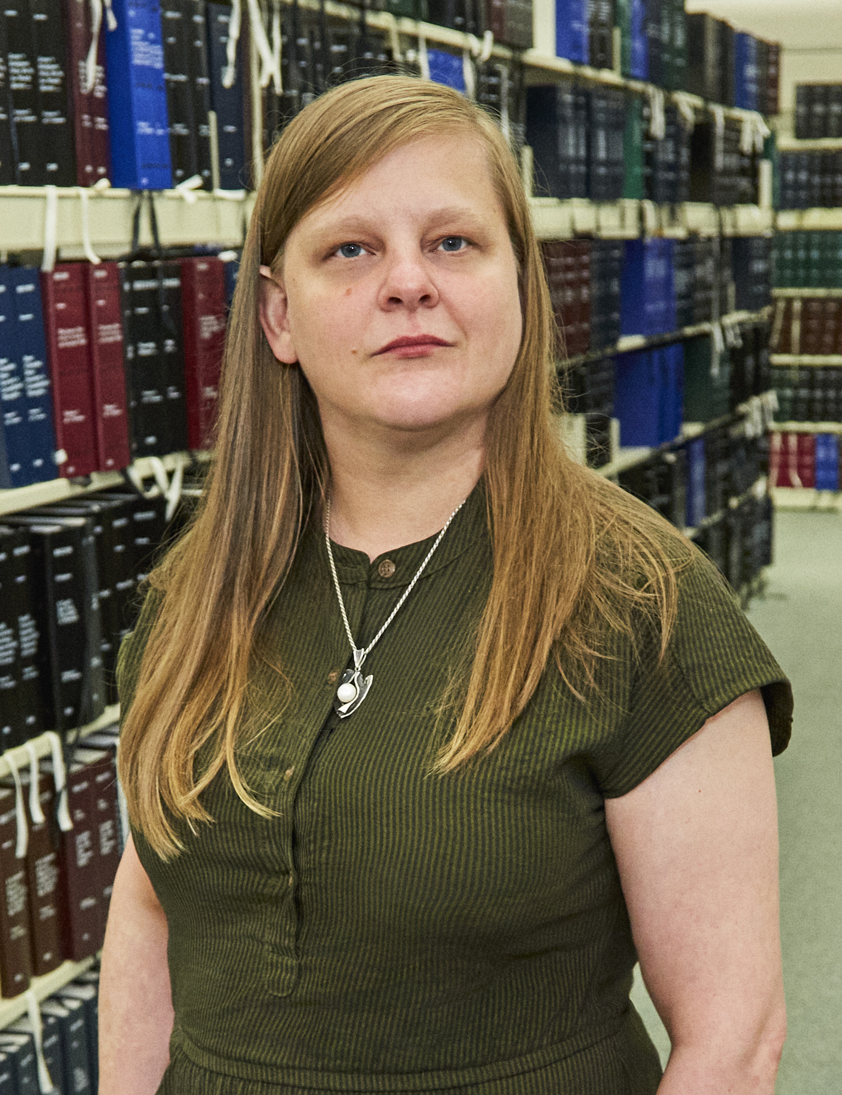 A white woman standing in a library.